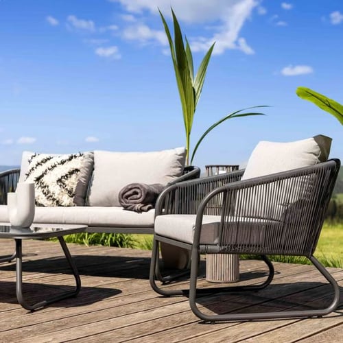 Moderne Gartenlounge auf einer Holzterrasse als stilvolle Gestaltungsmöglichkeit für einen Garten ohne Rasen