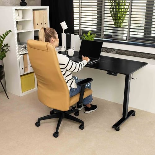 Frau arbeitet am Laptop an einem höhenverstellbaren Schreibtisch von di volio bei angenehmer Raumtemperatur im Büro