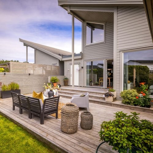Gartenmöbel auf erhöhter Terrasse am modernen Haus