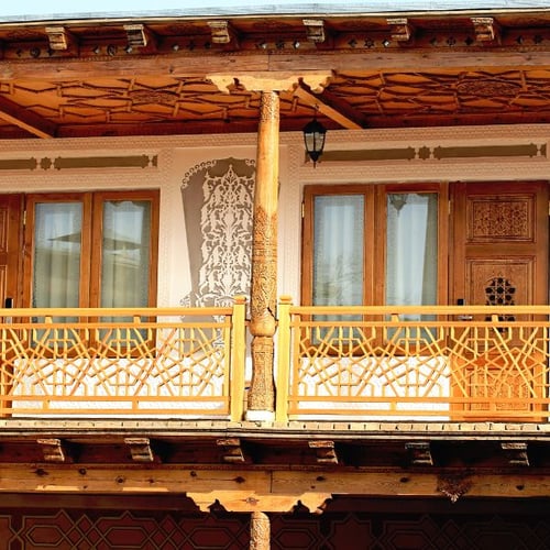 Orientalisch verzierter Holzbalkon mit traditionellen Mustern und warmen Naturtönen
