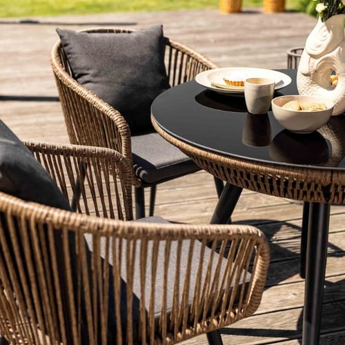 di volio polyrattan-Gartenstühle mit rundem Glastisch auf einer stabilen Holzterrasse
