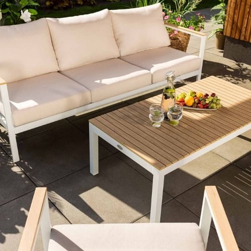 Di Volio Balkonmöbel für draußen mit weißem Sofa und Couchtisch in Holzoptik auf sonniger Terrasse