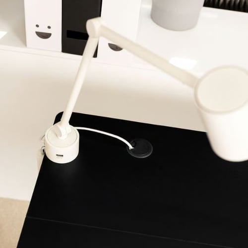 Moderne Kabelorganisation auf schwarzem Schreibtisch im Arbeitszimmer