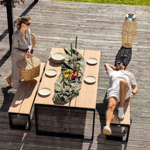 Moderne di volio Gartenlounge mit Tisch, Bänken und Dekoration auf Holzterrasse im großen Garten gestalten