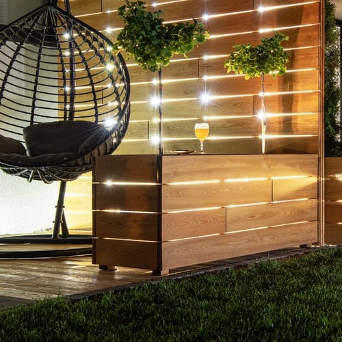 Beleuchtete di volio Gartenlounge mit Hängesessel und Holzsichtschutz für stilvolle Garten Bar Ideen