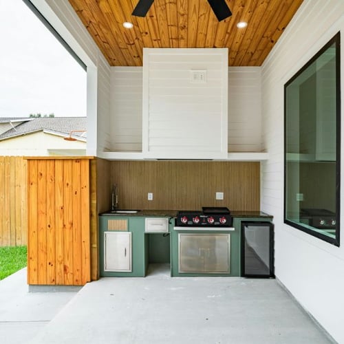 Überdachte Outdoor-Küche mit Gasgrill, Spüle, Mini-Kühlschrank und Holzverkleidung