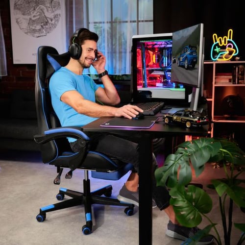 Mann am Gaming-Schreibtisch von di volio mit Headset, Monitoren und LED-Beleuchtung