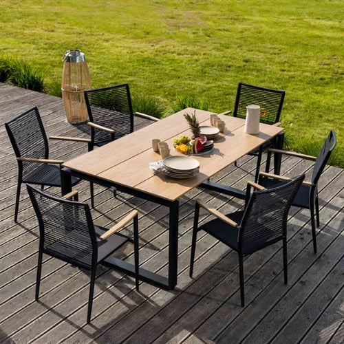 Moderner Gartentisch mit sechs Stühlen von di volio auf Holzterrasse, gedeckt zum Essen