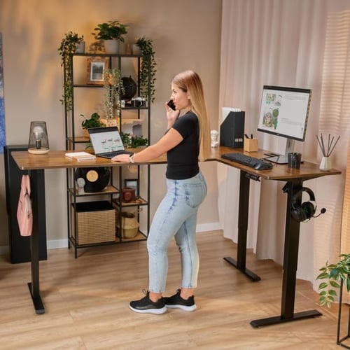 Frau arbeitet an Eckschreibtisch von di volio mit Laptop und Stehfunktion