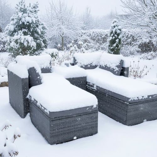 Rattan-Gartenmöbel mit dicken Schneeschichten im verschneiten Garten